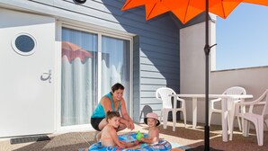 A patio area with a pool table, chairs, and an umbrella.