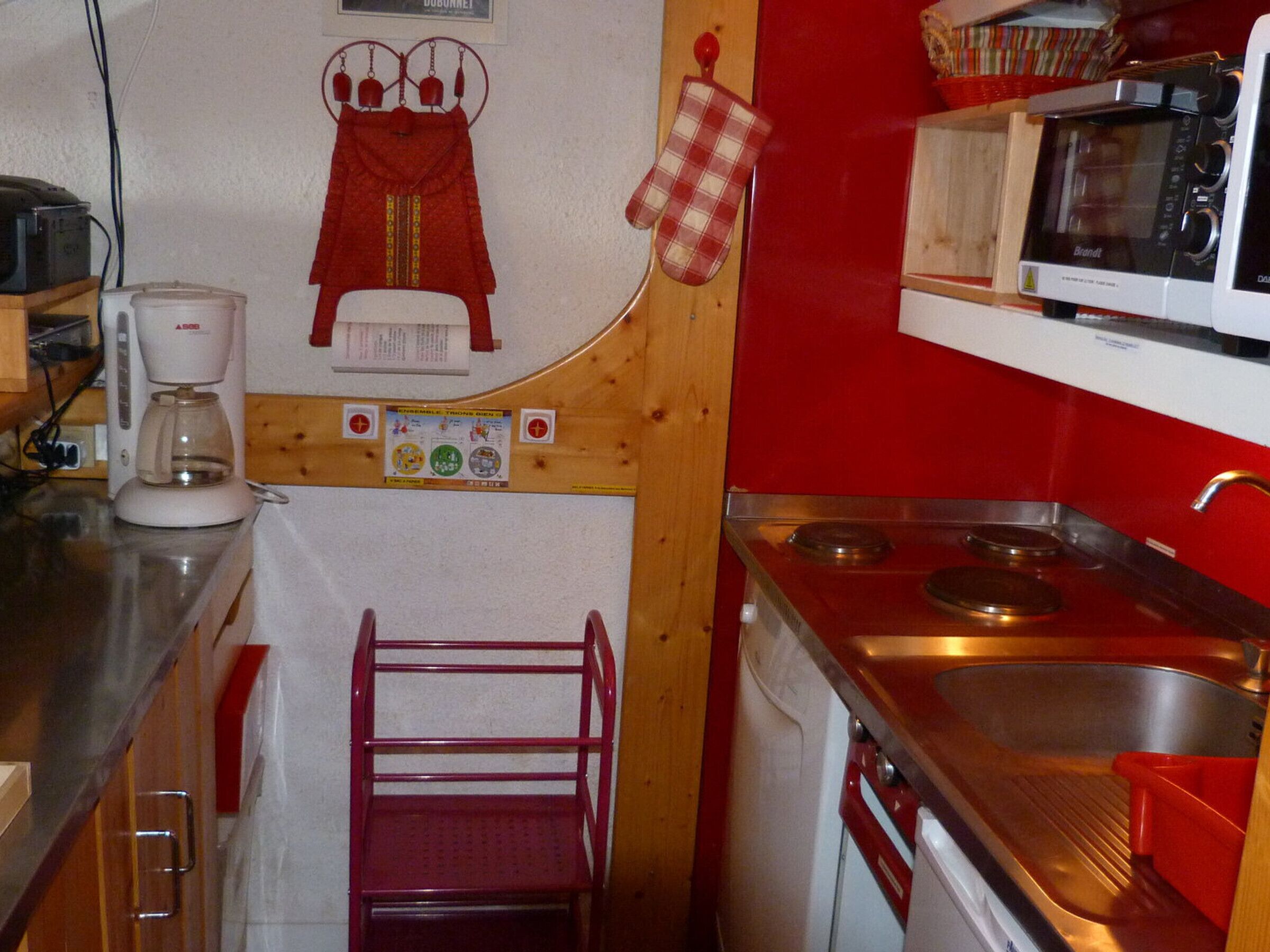 Une cuisine compacte équipée d’un four à micro-ondes, d’une cuisinière et d’une machine à café.