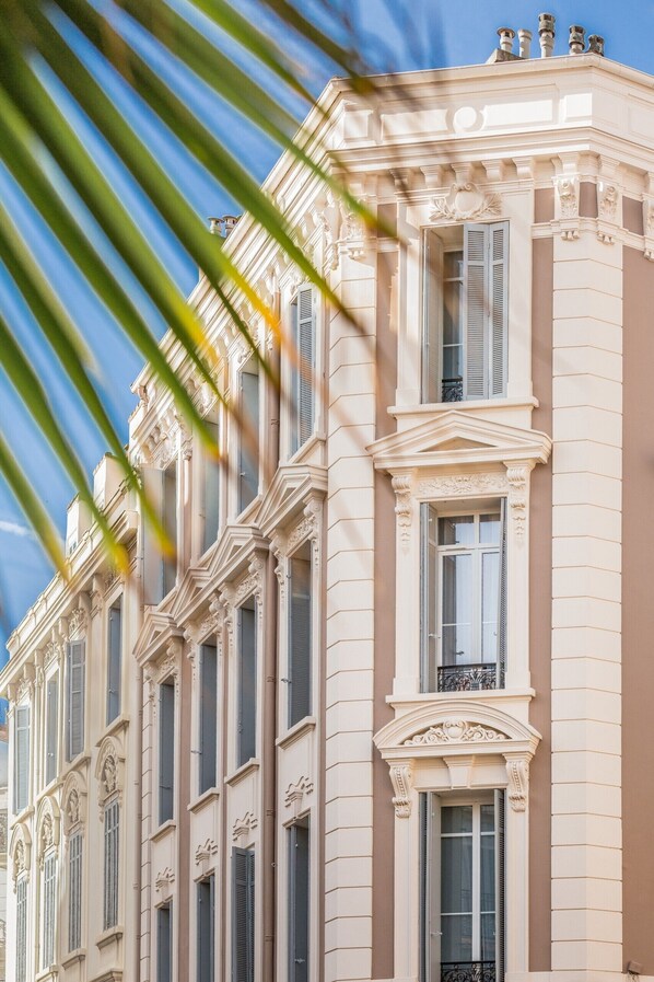 A classical building facade with symmetrical windows and decorative moldings.