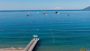 Eine Pier, die sich in ruhiges, blaues Wasser erstreckt, mit mehreren dort verankerten Booten.