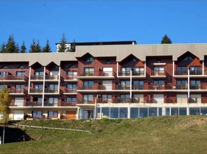 Ein mehrstöckiges Hotel mit Balkonen und großen Fenstern.