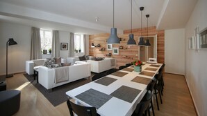 A modern living room with a sofa set, a dining table with chairs, and pendant lights. - grimm 160m2 city center 3br 3bth (Colmar)