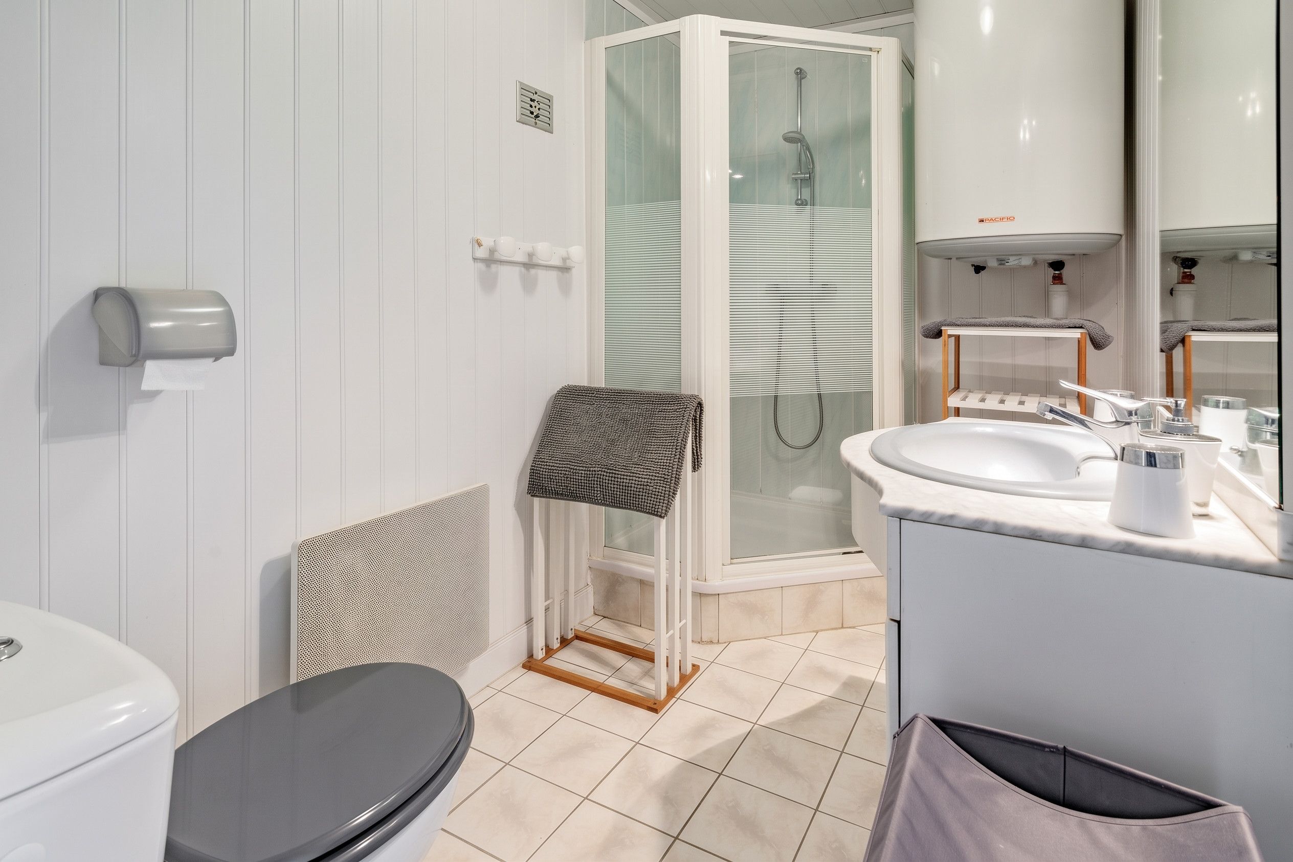 Une salle de bain moderne équipée de toilettes, d’une douche et d’un lavabo.