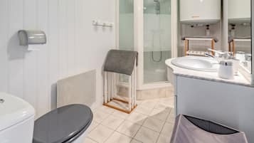Une salle de bain moderne équipée de toilettes, d’une douche et d’un lavabo.