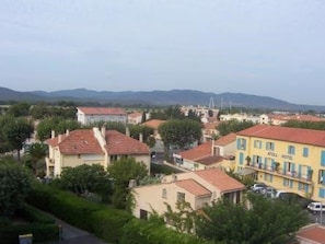 A hotel with a red roof, surrounded by greenery and other buildings. - Apartment in Fréjus with terrace and included cleaning (Fréjus)