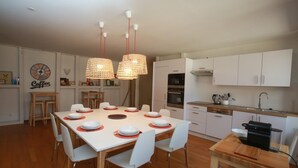 A modern kitchen with white cabinets, a dining table set for six, and a coffee-themed wall decoration. - bloch duplex 165m2 city center 4br3bth (Colmar)