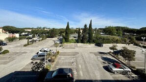 A parking lot with multiple cars and a few trees.