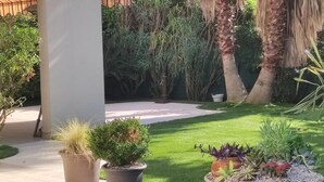 A well-maintained garden with a variety of potted plants and a lawn. - Deluxe garden level apartment, close to beaches, between Salis and Pinewoods (Antibes)