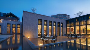 A modern building with a pool and outdoor seating area.