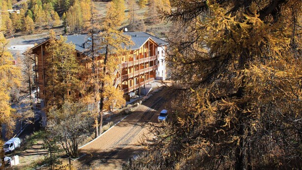 A lodge with a multi-story structure, surrounded by autumn foliage. - Central Apartment in Vars - 3 Rooms, Sleeps 6, Near Slopes & Shops (Vars)
