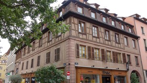 Un edificio histórico con una librería, ventanas amplias y una puerta roja.