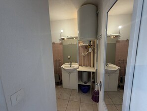 Ein Badezimmer mit zwei Waschbecken, einer Toilette und einer Dusche.