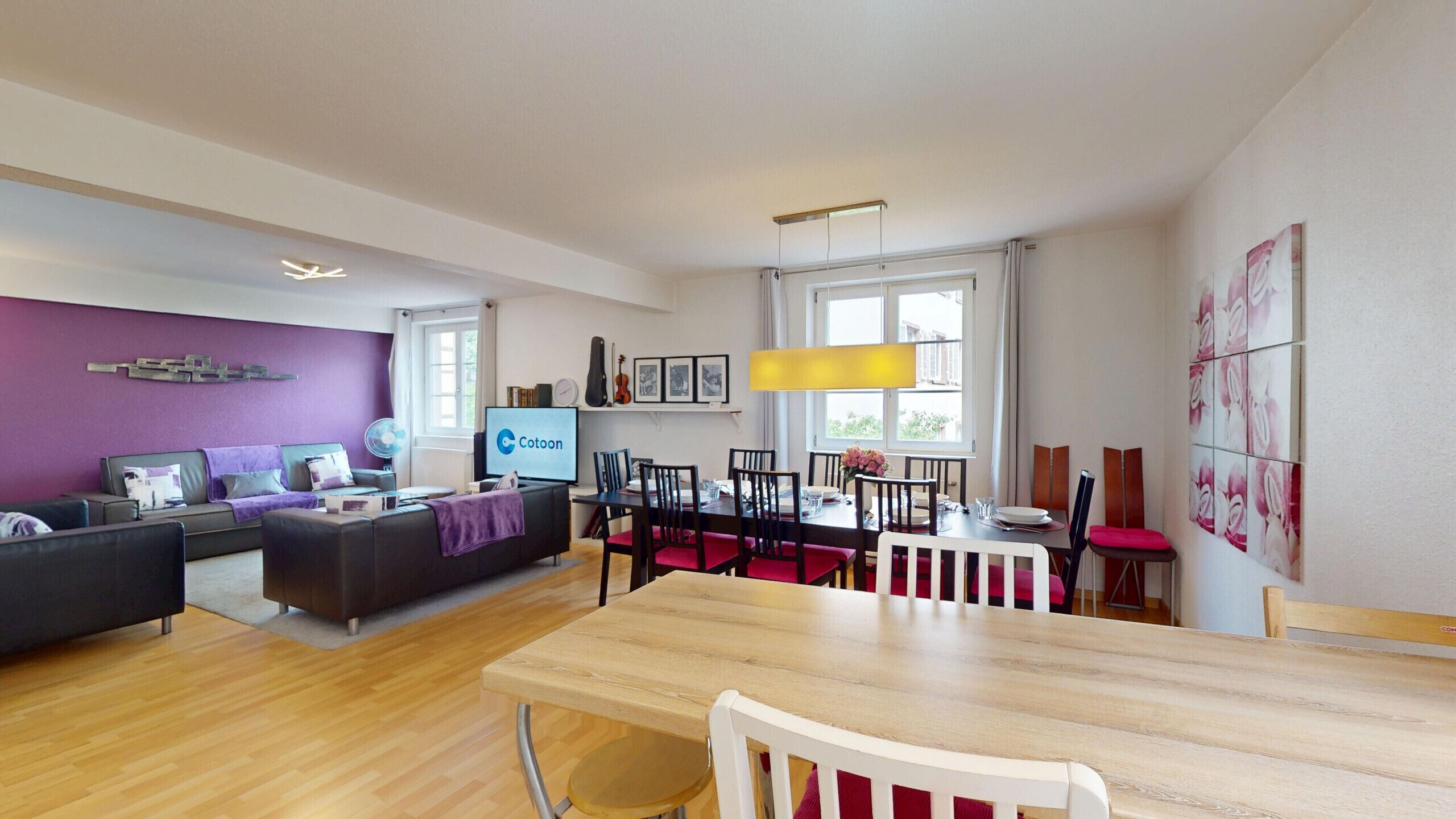 Ein modernes Wohnzimmer mit einer Couch, einem Esstisch und Stühlen.