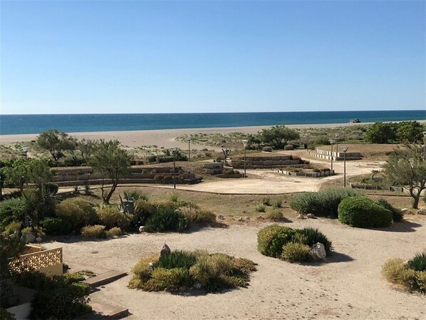 A coastal area with a sandy beach, some greenery, and a clear view of the sea. - 1BR at 50m from beach, Private Parking, 4 pers (Port Leucate)