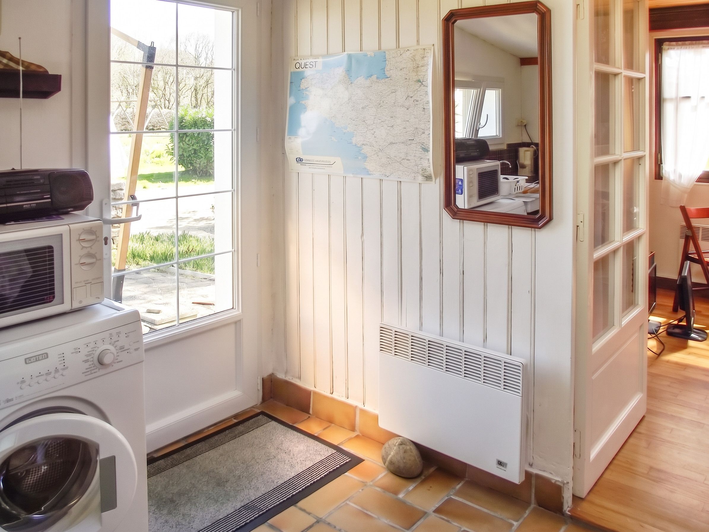 A laundry room with a washing machine, dryer, and a map on the wall.