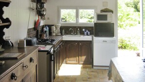 Una cocina con estufa, lavamanos, microondas y armarios.