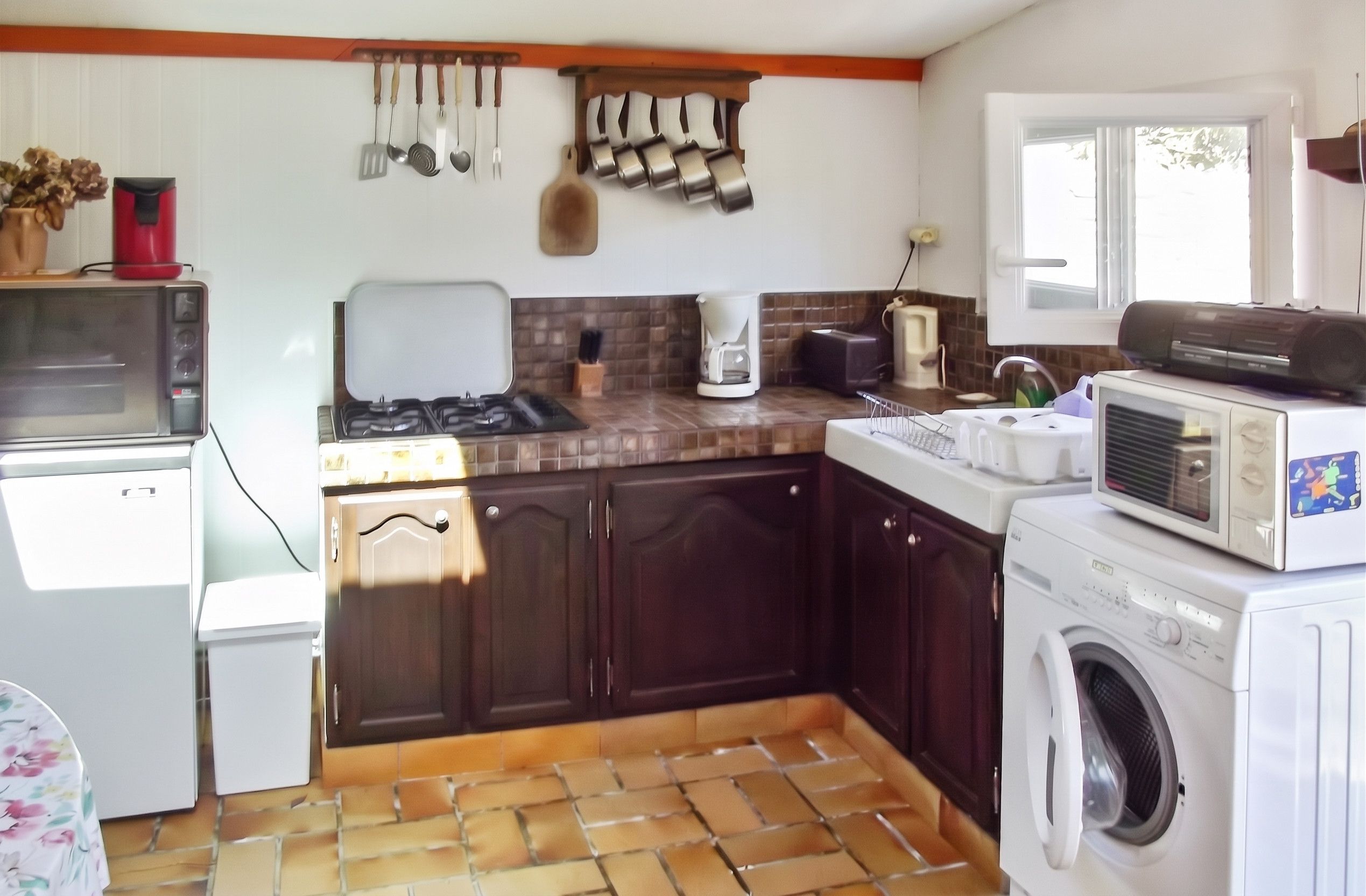 Cocina compacta con microondas, estufa, fregadero y lavadora.