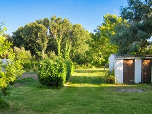 A well-maintained garden with a variety of trees and shrubs, a clear pathway, and a small shed. - Homerez - Charming House in Trédrez-Locquémeau + Garden (Trédrez-Locquémeau)