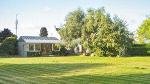 Una casa con techo inclinado y un árbol grande en el frente.
