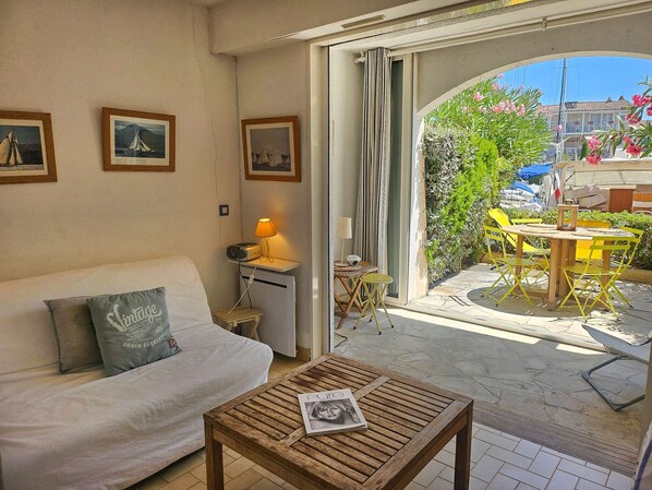 A cozy living area with a sofa, a coffee table, and a view of the outdoor patio.