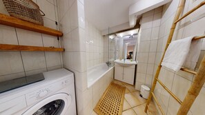 Bathtub, hair dryer, towels, toilet paper