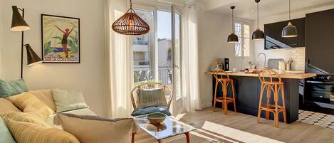 Un appartement moderne doté d’un coin repas, d’une cuisine et d’un balcon avec vue.
