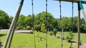 Ein Spielplatz mit Schaukeln und einer Wippe.