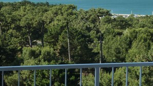 A view of a coastal area with dense green trees and a clear blue sea. - Renovated 1BR with balcony, covered parking, pets allowed (Les Sables-d'Olonne)