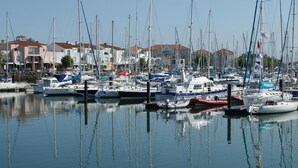 A marina with various boats docked, surrounded by buildings with red roofs. - Renovated 1BR with balcony, covered parking, pets allowed (Les Sables-d'Olonne)