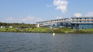 A modern building with a sign reading "Relais Thalasso" by the water. - Renovated 1BR with balcony, covered parking, pets allowed (Les Sables-d'Olonne)