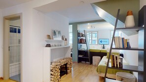 Un espace de vie moderne comprenant une cheminée, une bibliothèque et un bureau avec un ordinateur.