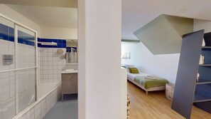 A modern bathroom with a bathtub, shower, and a mirror.