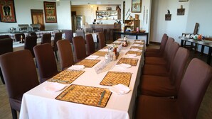 A long dining table set with brown chairs, white tablecloths, and woven placemats. - Ngorongoro Wild Camps (Ngorongoro)