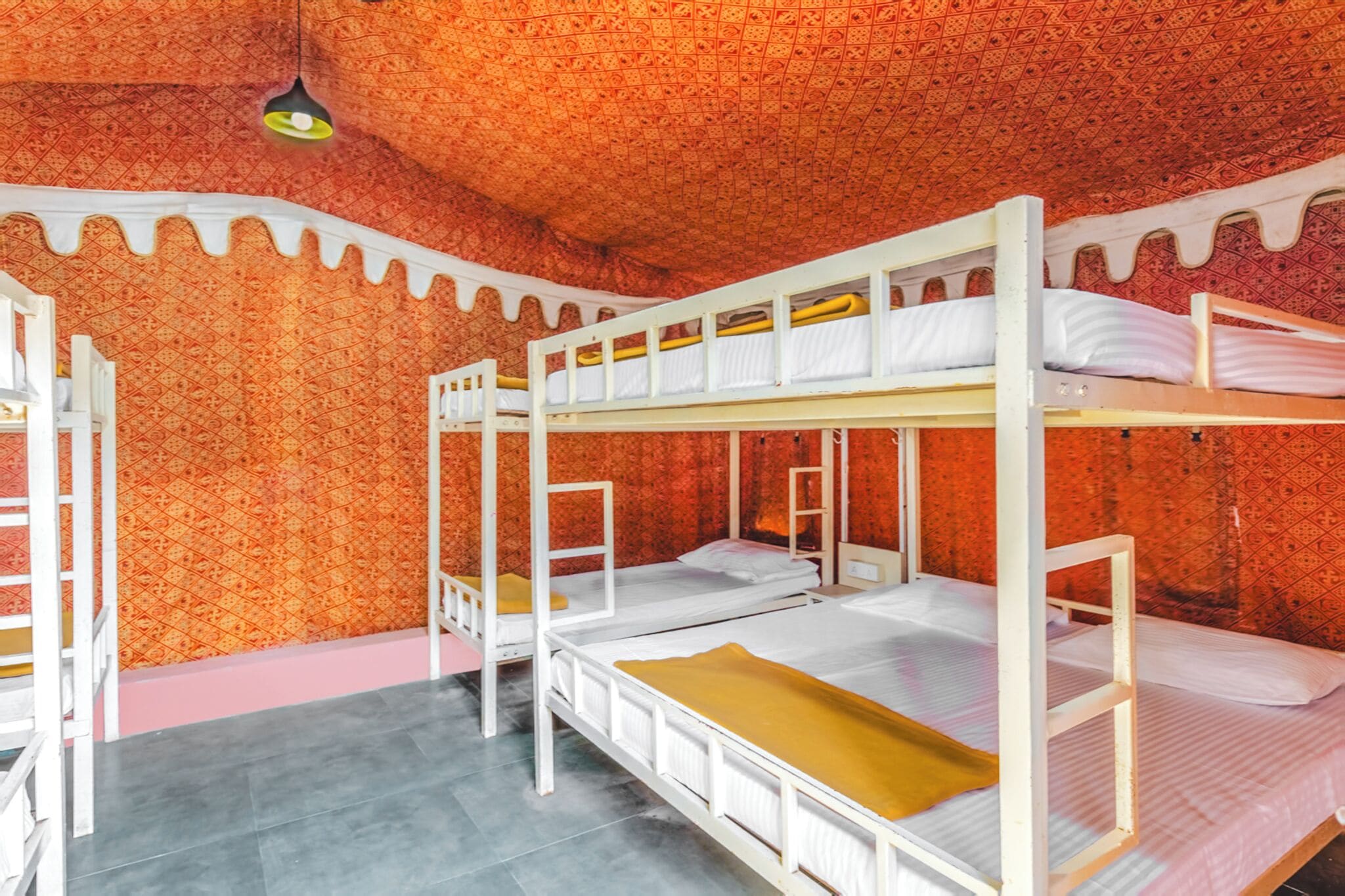 A room with bunk beds, a patterned wall, and a light fixture.