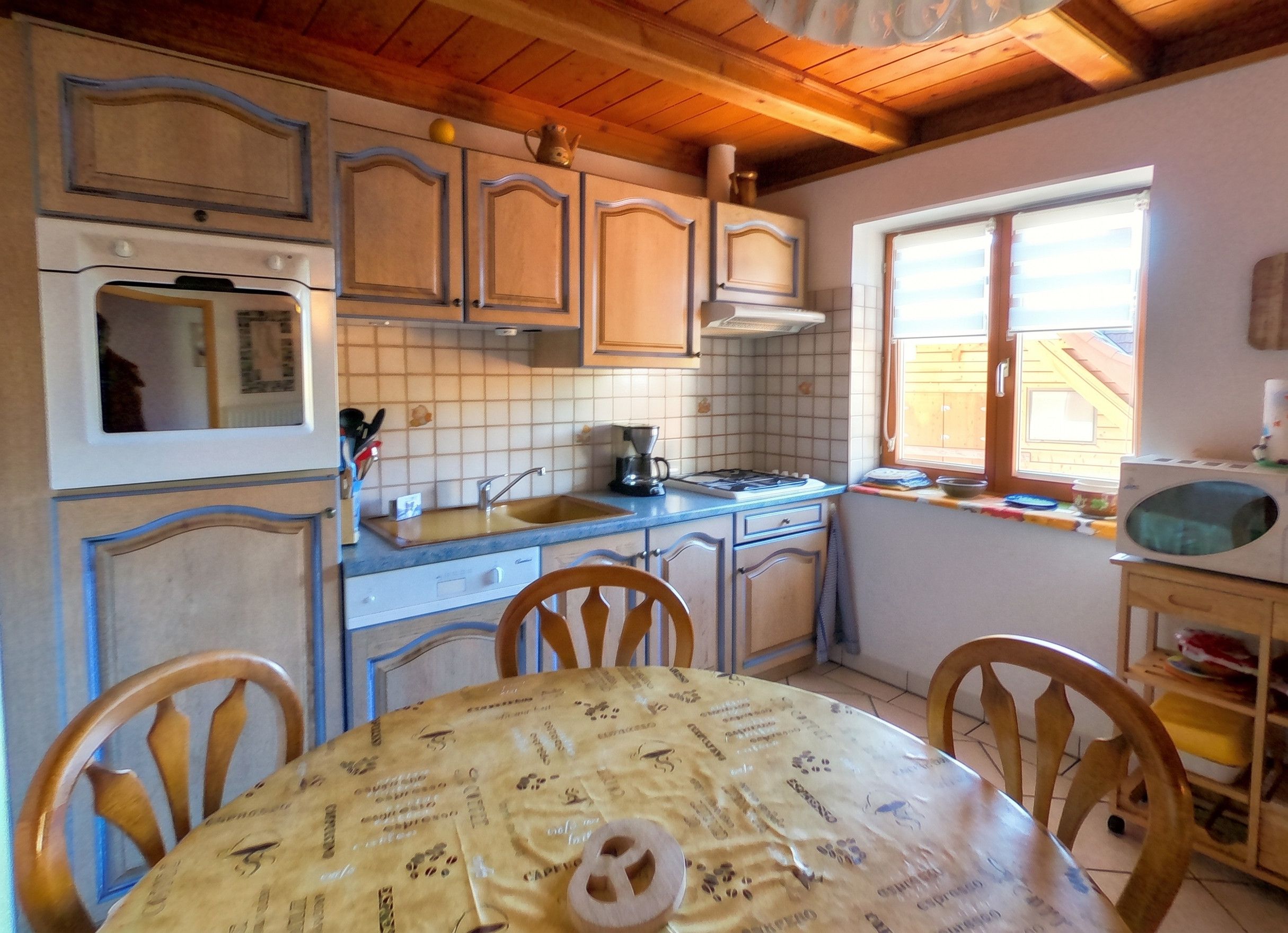Una cucina con mobili in legno, un fornello, un lavello e una finestra.