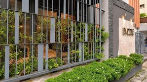 A modern building with a metal fence, greenery, and a sign that reads "Dazzle". - Dazzle Residence (Bangkok)
