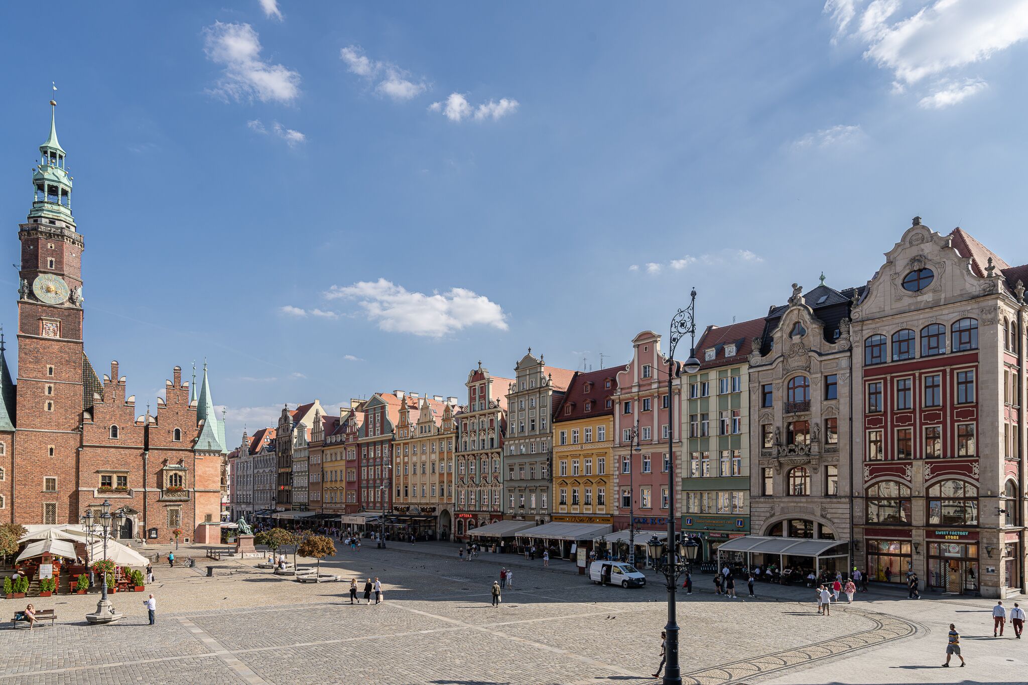 A historic square with a prominent clock tower and colorful buildings.