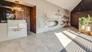 Una moderna zona de recepción con un mostrador de madera, un mural en la pared y una alfombra estampada.