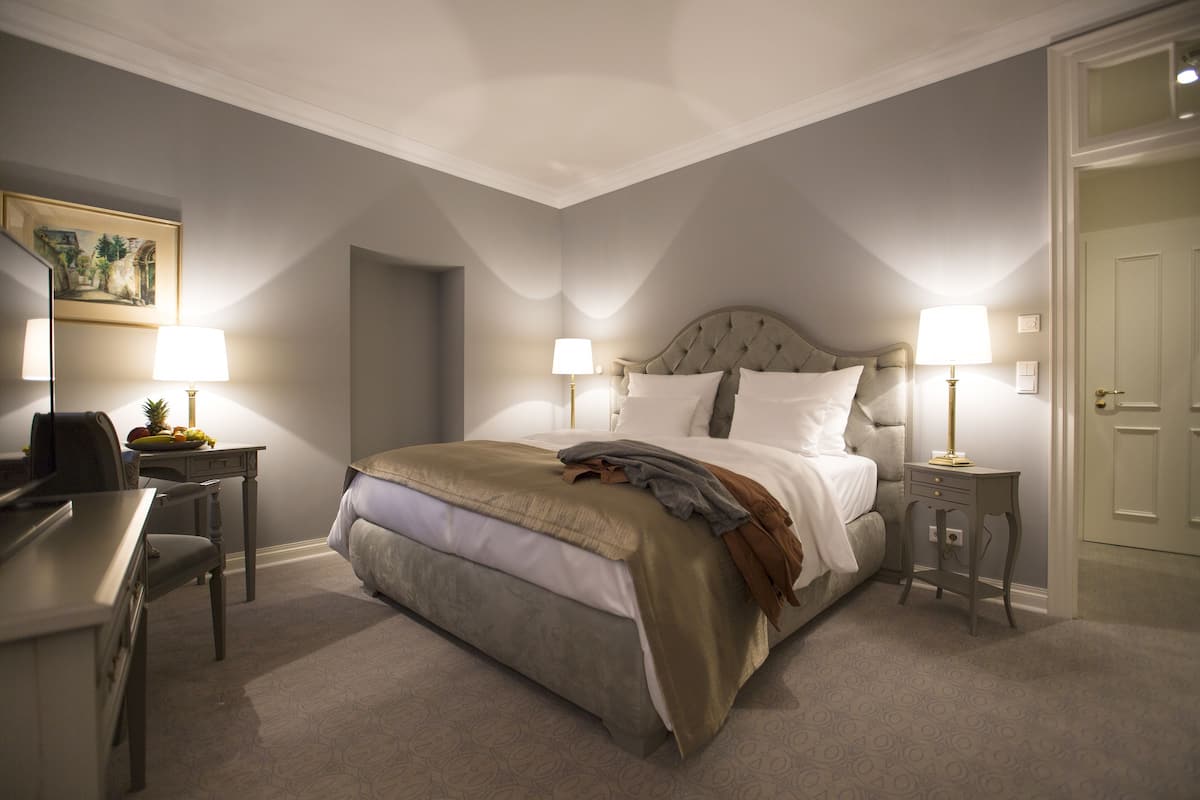 Une chambre à coucher avec un lit, des tables de chevet, un bureau et une chaise.