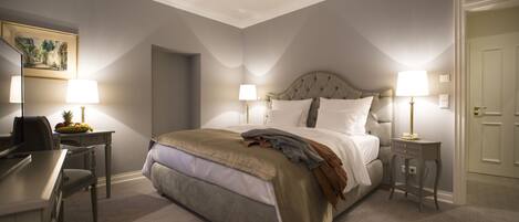 A bedroom with a bed, bedside tables, a desk, and a chair.
