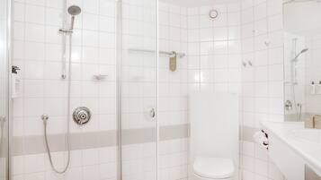 A modern bathroom with a glass-enclosed shower, a toilet, and a sink with a mirror.