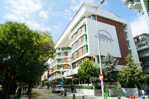 Un hotel de varios pisos con un diseño moderno, que cuenta con balcones y ventanas amplias.