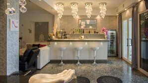 Een moderne keuken met een marmeren aanrecht, barstoelen en een decoratieve handsculptuur.