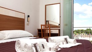Een hotelkamer met een bed, een bureau en uitzicht op het omliggende landschap.