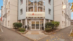 Un immeuble sur lequel on peut lire l’inscription : « City Residence, hôtel-appartements ».