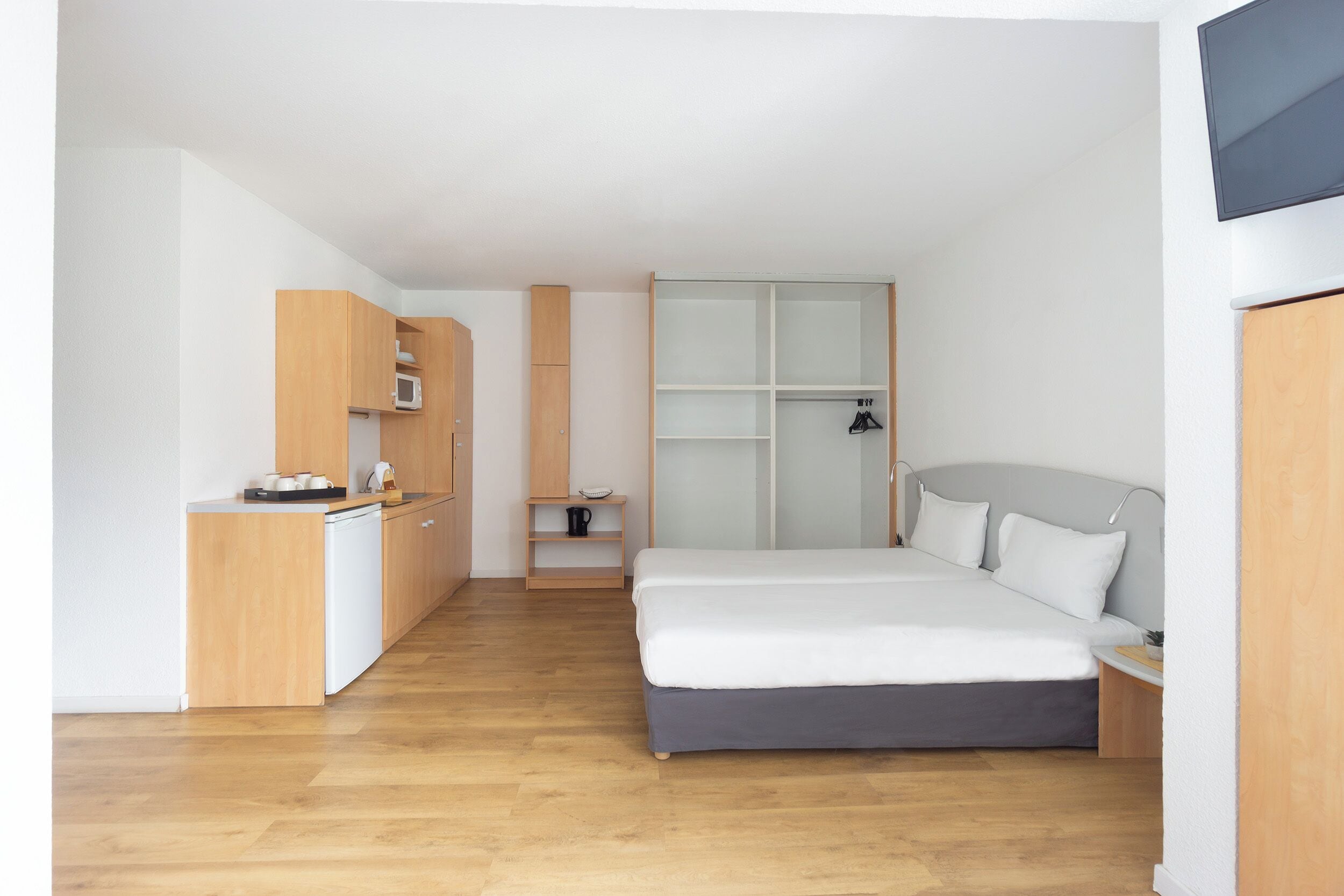 Une chambre à coucher moderne avec un lit, une table de chevet et une armoire intégrée.