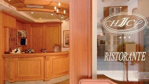 Un interior de madera con una mesa de recepción y un cartel que dice 'HJCP RISTORANTE'.