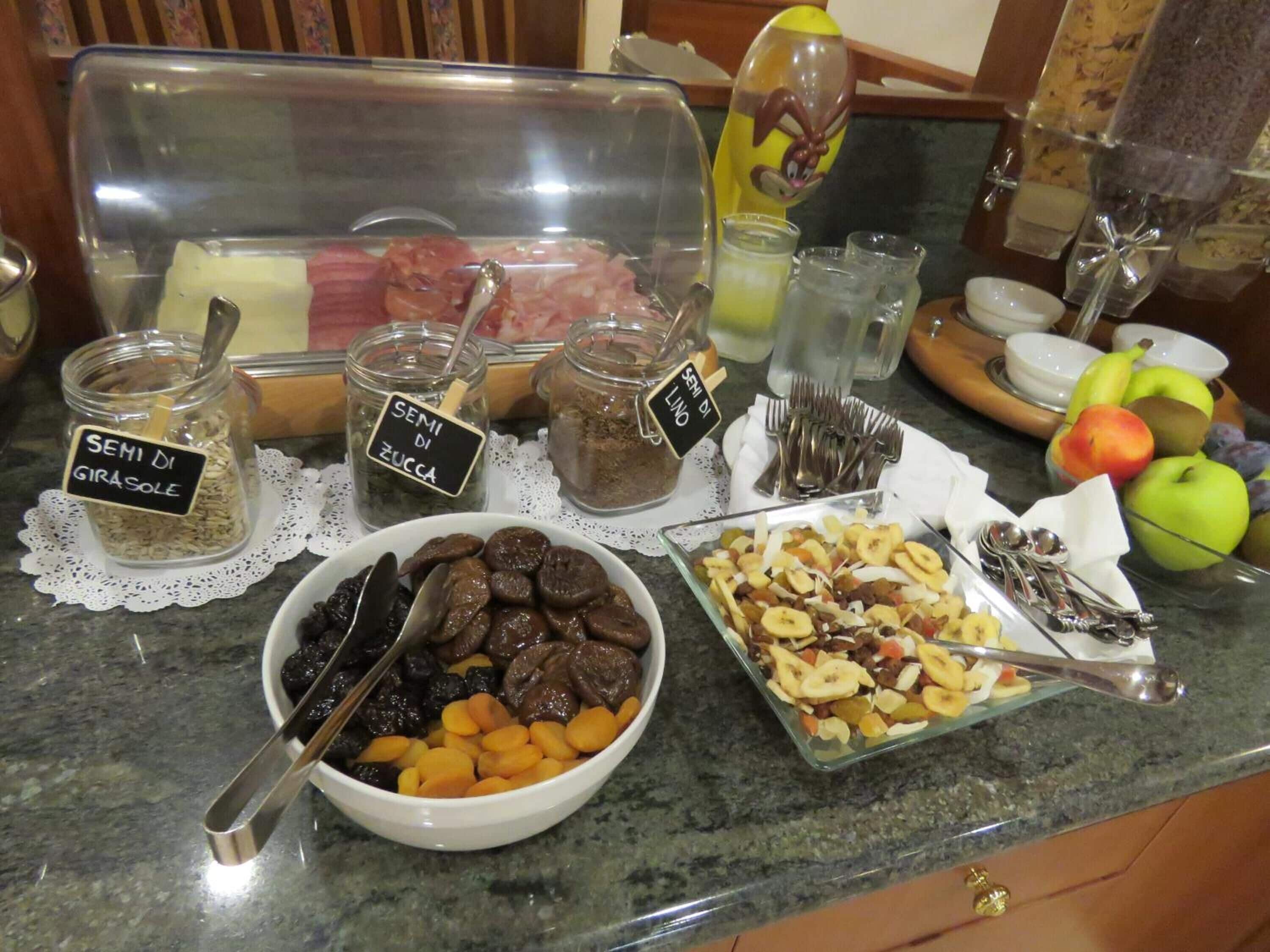 A buffet with various food items including jars of dried fruits, nuts, and meats.