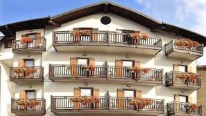 Un edificio de varios pisos con balcones decorados con flores.