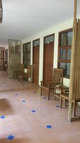 A hallway with wooden doors, chairs, and a bamboo screen.